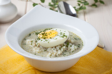 Sorrel soup with egg in white bowl.