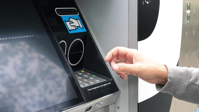 A woman withdraws money at ATM with a card