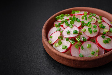 Fototapeta na wymiar Delicious fresh salad of sliced ??radishes with green onions, salt and olive oil