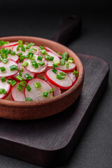 Delicious fresh salad of sliced ??radishes with green onions, salt and olive oil