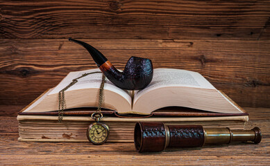 Fototapeta na wymiar Tobacco pipe, pocket watch and spyglass on the books