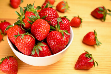 white bowl  of strawberries on wooden table