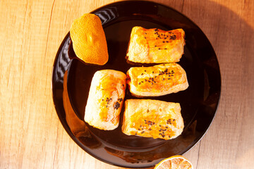 pastry, fritters on a black plate, wooden floor