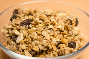 muesli in a glass plate on an orange background