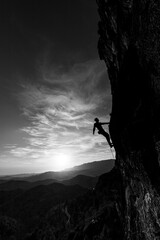 man climbing at sunset in the mountains with the forest in the background, copy space, business, security, trust