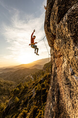 man climbing at sunset in the mountains with the forest in the background, copy space, business,...