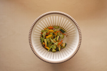 throwing vegetables in a garbage bin 