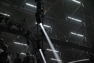 Stage truss with concert light. Beam light. Exhibition dark background. Industial concert background