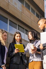 multiethnic group of business people smiling and checking on a tablet their work project