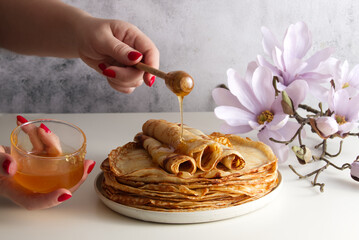 Stack of fresh crepes with honey and raspberries on the table copy space