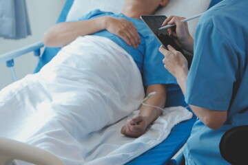 Fototapeta premium Women Asian doctors hold the patient hand and encourage and provide medical advice While checking the patient health in bed. Concept of Care and compassion, antenatal care, Threatened abortion