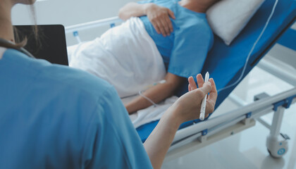 Fototapeta premium Women Asian doctors hold the patient hand and encourage and provide medical advice While checking the patient health in bed. Concept of Care and compassion, antenatal care, Threatened abortion