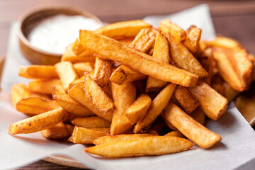 French fries, pommes frites on a plate with mayonaise, salty snack closeup