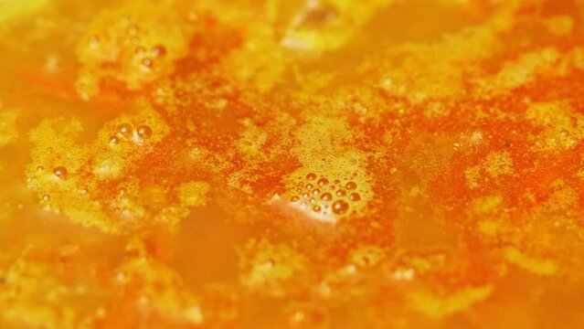 Red lentil indian soup is boiling close up. Cooking process lentil soup. Traditional middle eastern vegetable spicy soup. Macro video