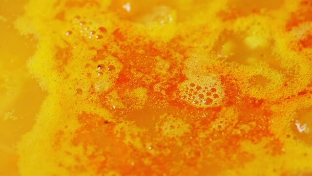 Red lentil indian soup is boiling close up. Cooking process lentil soup. Traditional middle eastern vegetable spicy soup. Macro video