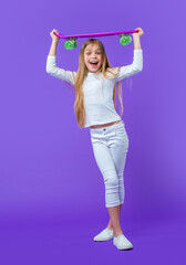 photo of surprised teen girl skateboarder. teen girl skateboarder isolated on purple.