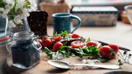 Helathy food for breakfast with red tomatoes and fresh bread.  Mug of coffee and diet with vegetables on a table with kitchen. 