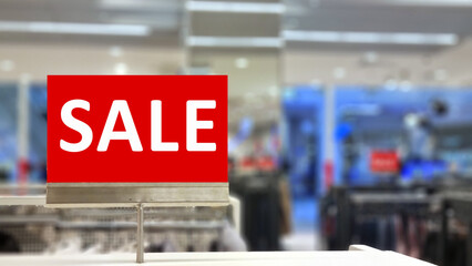 The sale inscription is on a red sign in the store. focus on the inscription. 
