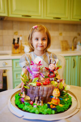 little girl with a large cake with figures of fairy-tale characters