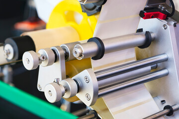Fragment of the conveyor of sticking labeling machine. Abstract industrial background.