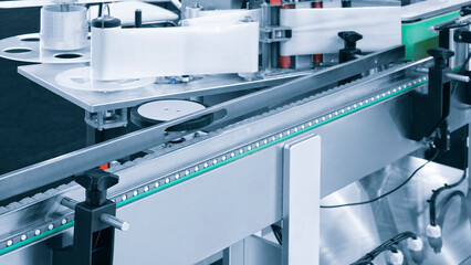 Fragment of the conveyor of sticking labeling machine. Abstract industrial background.
