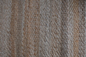 Woven jute rug, modern natural braided jute living area rug design. Wicker carpet concept idea photo. Eco-friendly interior detail in home. 