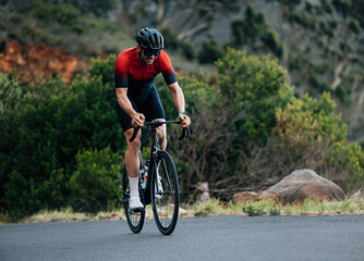 Obraz na płótnie Canvas Male road bike rider doing intense and tough training in wild terrain