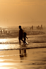 Silhouettes of people on the beach at sunset