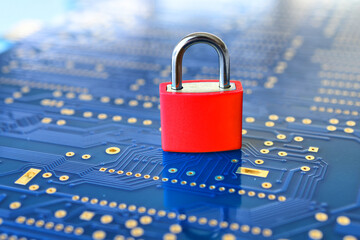 Cyber security concept background - red padlock on blue computer motherboard circuit board...