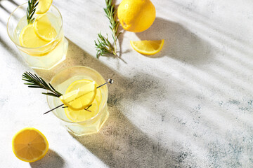 Summer refreshing drinks with fresh lemon slices and rosemary sprigs. Alcoholic cocktails with...