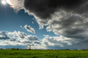 Wieża wiertnicza na tle wiosenej łąki / Drilling rig against the background of a spring meadow