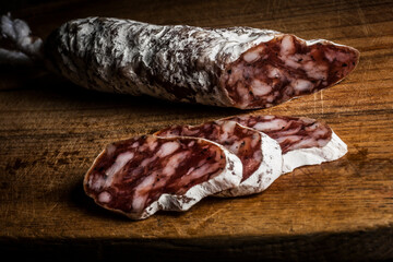 Sausage with mold sliced on wooden table
