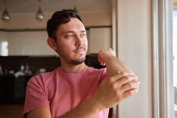 Senior man lubricating with analgetic cream his elbow.