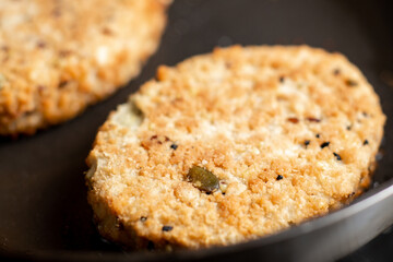 Vegetarian cutlets are fried in a pan. Meat alternative food. Cutlets from beans, seeds. Close-up macro.