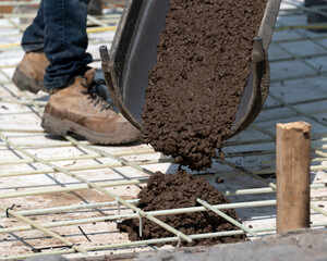 Workers pouring concrete for a stamped floor