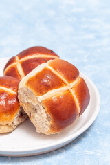 Freshly baked hot cross buns on white plate. Traditional easter food, vertical, copy space