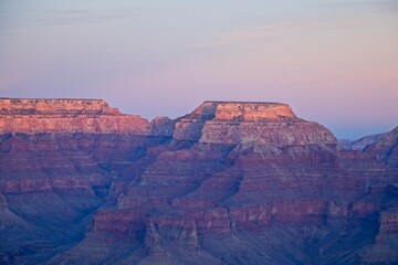 Bright desert sunlight shines down on the Grand Canyon, casting shadows on every crease and layer...