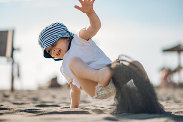 Adorable toddler child boy playing in the sand on a on beach