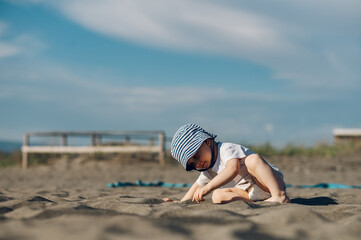 Adorable toddler child boy playing in the sand on a on beach