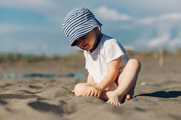 Adorable toddler child boy playing in the sand on a on beach