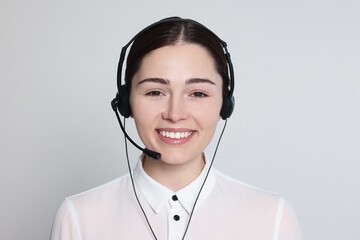Hotline operator with modern headset on light grey background. Customer support