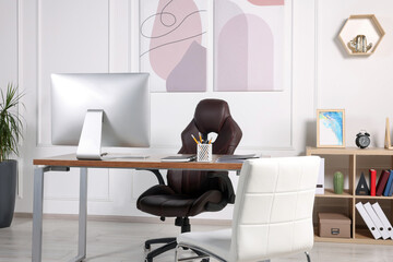 Director's workplace with wooden table, computer and comfortable armchairs. Interior design