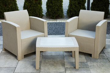 Comfortable armchairs and coffee table outdoors. Beautiful rattan garden furniture