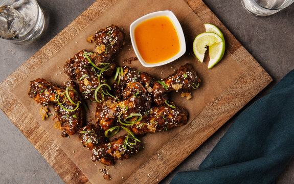 Gourmet chicken wings with greens, lime and sesame seeds