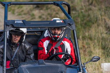 Naklejka premium A man driving a quad ATV motorcycle through beautiful meadow landscapes
