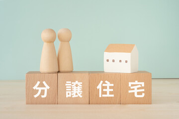 分譲住宅と書かれたブロックと人形と家