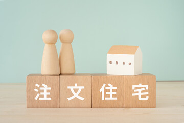 注文住宅と書かれたブロックと人形と家