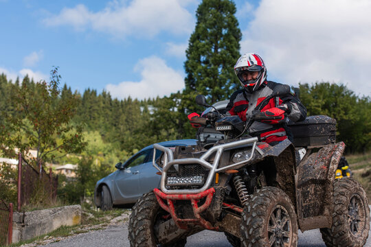 Adventurous driving of ATV motorbikes. A man drives a quad bike on dangerous roads