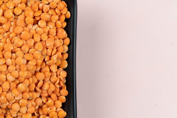 Red lentil in bowl isolated on pink background. Top view