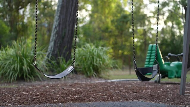 Abandoned toy swing moving at a playground